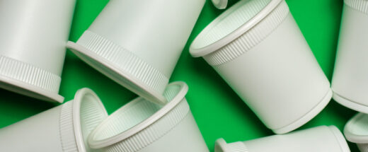 Bioplastic cups on a green background