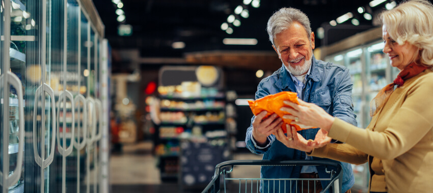 A couple in a grocery store reading product packaging